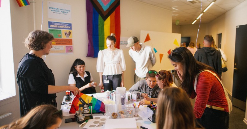 Erika and Devin chat with students while tabling for their respective affinity groups.
