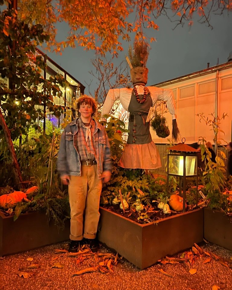Oli poses by a scarecrow.